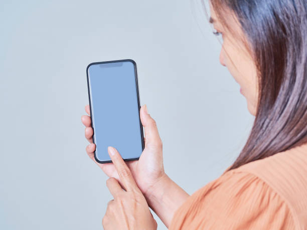 istock Woman hand holding smartphone on gray background 1283681254