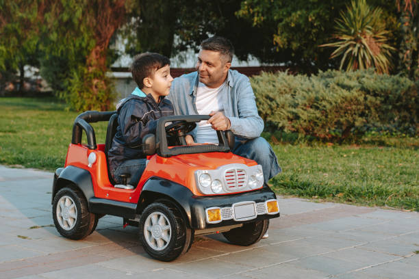 Father and son playing in the park Father and son playing in the park kid toy car stock pictures, royalty-free photos & images