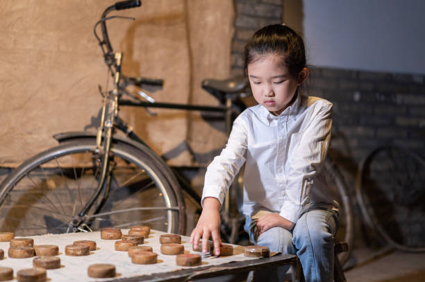 petite fille jouant des échecs chinois - chinese chess leisure games chinese culture traditional culture photos et images de collection