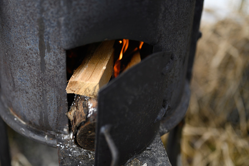 logs, burn, stove, cast iron, outdoors, background, backyard, black, cast, closeup, color, concept, countryside, day, domestic, energy, fire, fireplace, firewood, flame, fuel wood, glowing, heat, hot, iron, life, lifestyle, log, metal, natural, nature, no people, nobody, object, open air, outside, rural, rustic, scene, season, stone, street, time, traditional, warm, warmth, wild, winter, wood, wooden