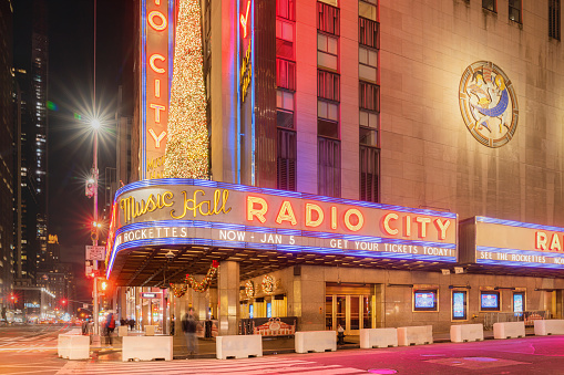 New York City, NY, USA- November 28, 2019:A long exposure of travel heading up Sixth Ave. past Radio City Music Hall in New York, New Yor