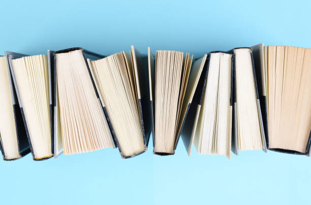 istock High angle image of a row of books standing on end on a light blue background 1283687122