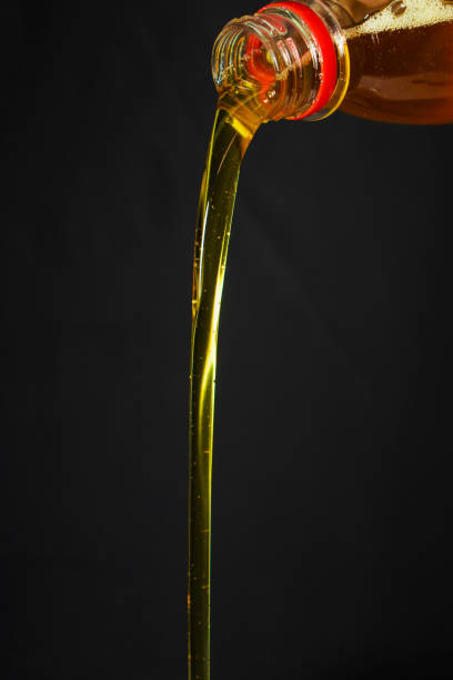 istock Pouring olive oil from a bottle on darck background 1283687451