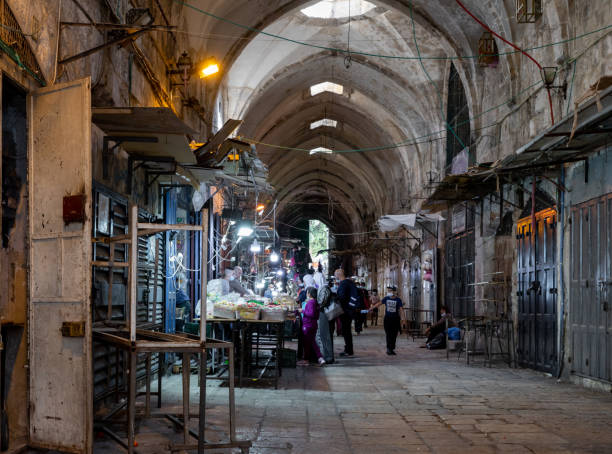 poucos compradores compram nas poucas lojas abertas na rua suq el qatanin, na parte muçulmana da antiga cidade de jerusalém, israel - el aqsa - fotografias e filmes do acervo