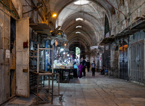 poucos compradores compram nas poucas lojas abertas na rua suq el qatanin, na parte muçulmana da antiga cidade de jerusalém, israel - el aqsa - fotografias e filmes do acervo