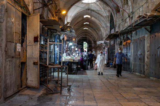 poucos compradores compram nas poucas lojas abertas na rua suq el qatanin, na parte muçulmana da antiga cidade de jerusalém, israel - el aqsa - fotografias e filmes do acervo