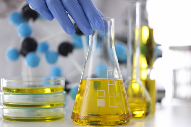 naukowiec w gumowych rękawicach trzyma kolbę szklaną z żółtą cieczą w zbliżonej laboratorium chemicznym - extraction fossil fuels zdjęcia i obrazy z banku zdjęć