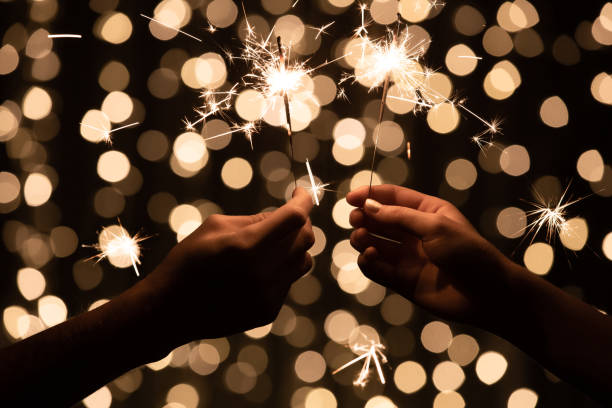 istock Close up of two people's hands with sparklers burning in them 1283688230