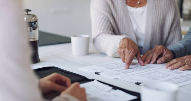 Making retirement a time for gains Cropped shot of a senior couple meeting with a consultant to discuss paperwork at home pension photos stock pictures, royalty-free photos & images