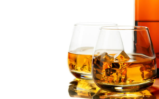 glass of whisky and ice on a white background - brandy bottle alcohol studio shot imagens e fotografias de stock