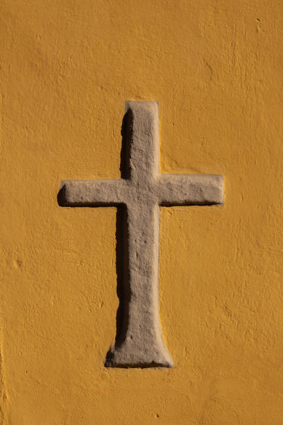 istock Stone cross walled in a orange wall 1283692483
