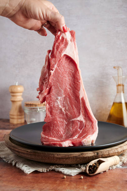 istock A hand holding a fresh meat steak for cooking 1283692811