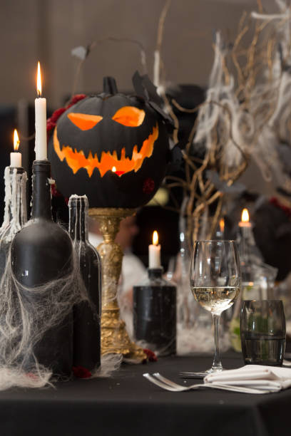 istock Table set for Halloween dinner. Served holiday table with candles and pumpkin 1283693189