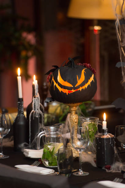 istock Table set for Halloween dinner. Served holiday table with candles and pumpkin 1283693313