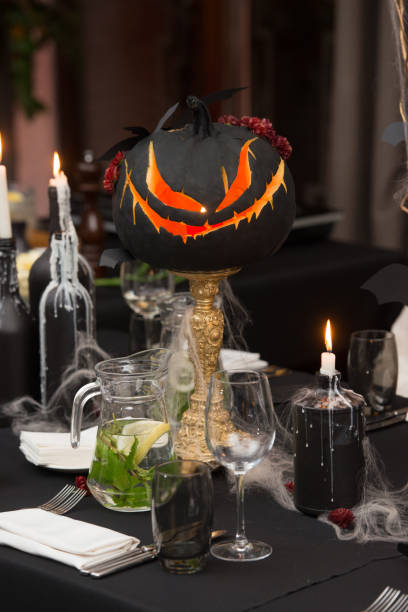 istock Table set for Halloween dinner. Served holiday table with candles and pumpkin 1283693344