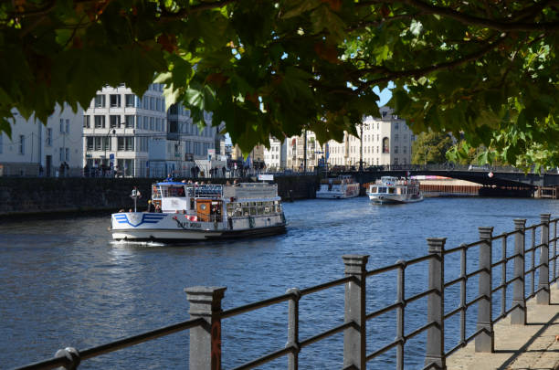 Berlin, Germany - October 11, 2014: tourist boat is passing by at Berlin Spree River. People walking along the promenade