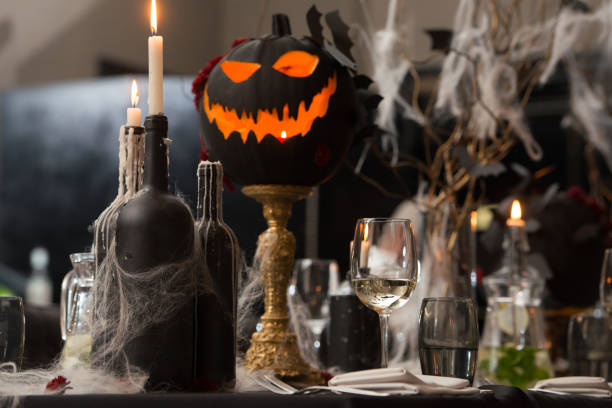 istock Table set for Halloween dinner. Served holiday table with candles and pumpkin 1283694146