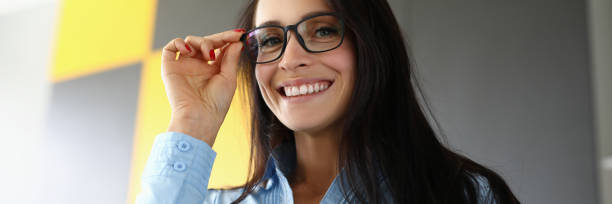 istock Brunette smiles and holds hand for glasses closeup 1283694306