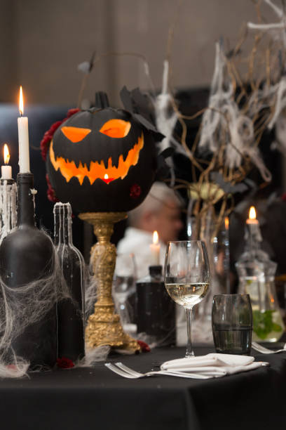 istock Table set for Halloween dinner. Served holiday table with candles and pumpkin 1283694391