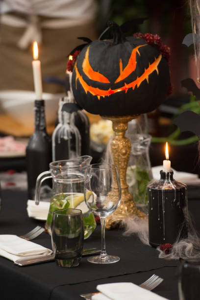 istock Table set for Halloween dinner. Served holiday table with candles and pumpkin 1283694734