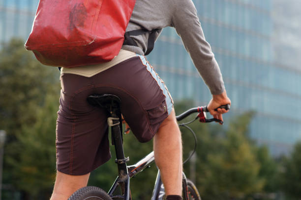 istock Bicycle messenger - commuter with messenger bag bicycle in Berlin delivering a parcel 1283694842