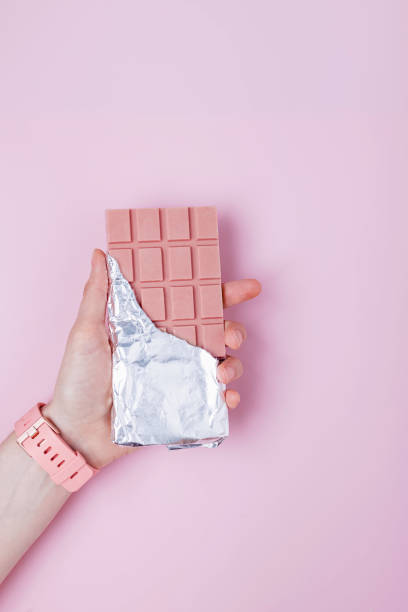 istock Hand holds chocolate bar in foil. 1283695131