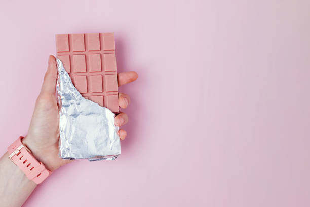 istock Hand holds chocolate bar in foil. 1283695133