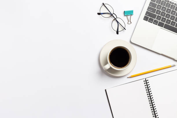 istock Top view white office desk with notebook, Laptop computer and Coffee cup with ,office supplies on white background 1283695436