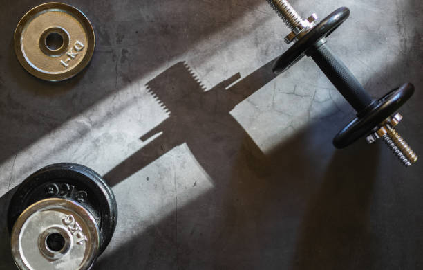 istock Dumbbells and various weight plates on a concrete surface. Background with empty space. 1283696309