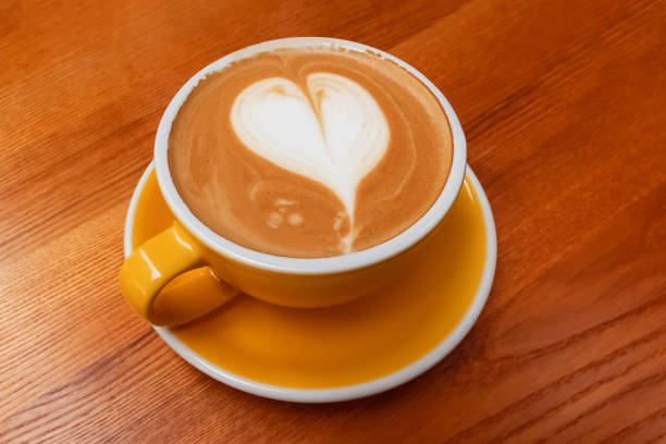 istock Yellow cup of coffee with heart shaped latte art 1283696534