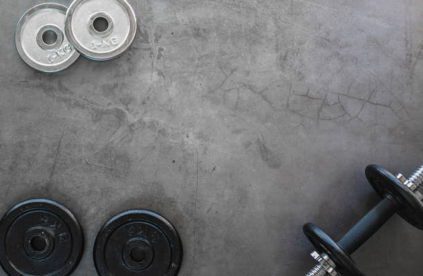 istock Top view of weight plates and dumbbells on a textured background with empty space 1283696539