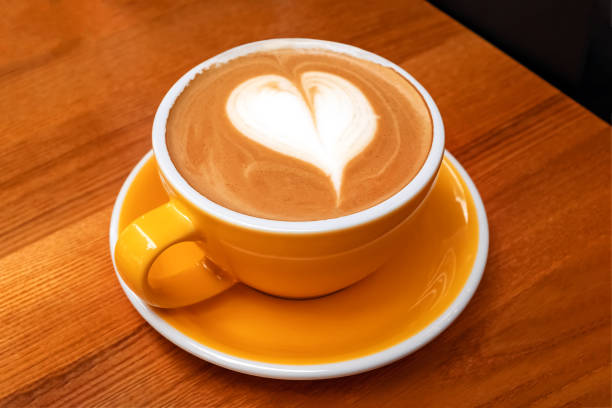 istock Yellow cup of coffee with heart shaped latte art 1283696541