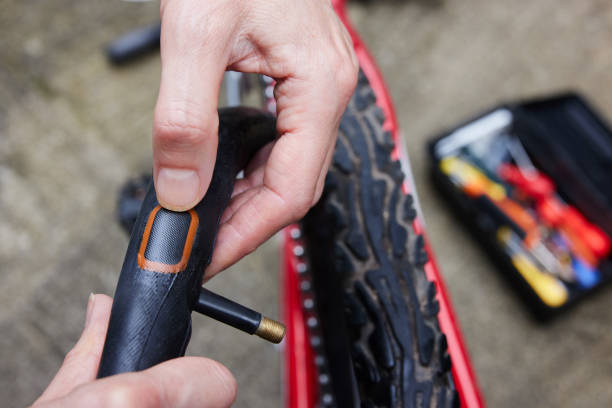nahaufnahme der person reparatur puncture in bike-reifen mit patch - reifenschlauch stock-fotos und bilder