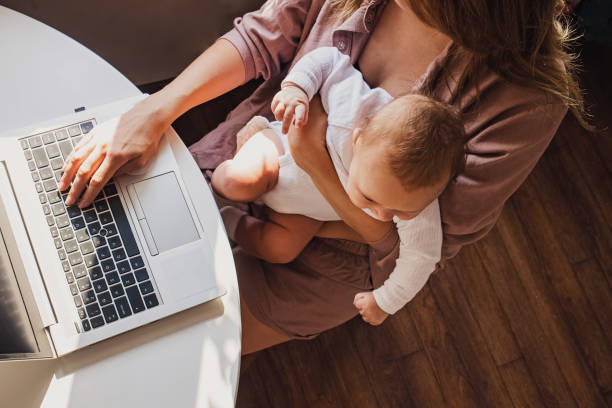 istock Young mom working remotely on laptop while taking care of her baby. 1283697091