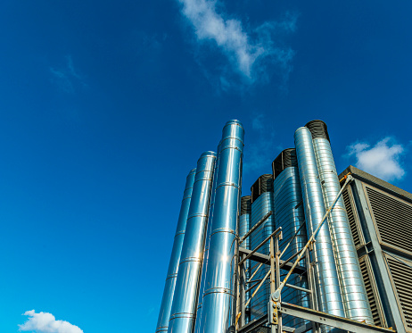 Large building and industrial plant chimneys  against a clear blue sky