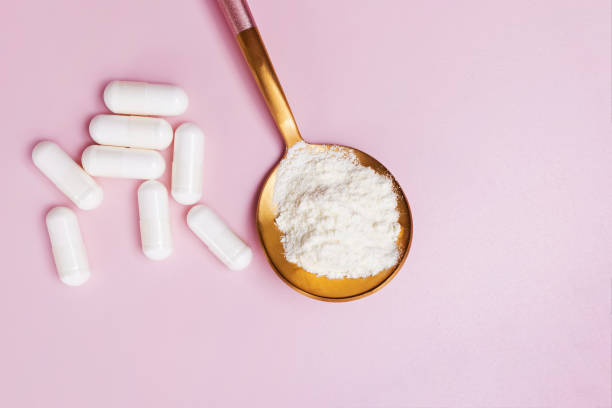 istock Collagen or protein powder in a spoon and white capsules 1283701549