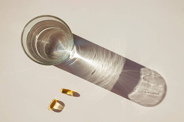 istock Glass of water and capsules with omega3 1283701555