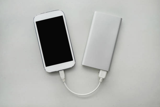 外出先で携帯電話を充電するためのパワーバンク - mobile phone charging power plug adapter ストックフォトと画像