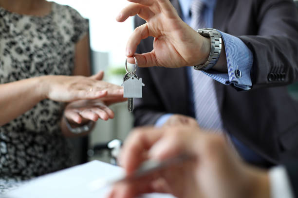 hombre dando llaves al nuevo dueño de la casa - real estate mortgage document key contract fotografías e imágenes de stock