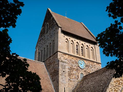 The tower of St Lawrence church in Castle Rising, Norfolk, Eastern England. St Lawrence church is a very heavily restored Norman church containing a genuine 12th century font. Most of the restoration, both inside and outside, was undertaken during the 19th century.