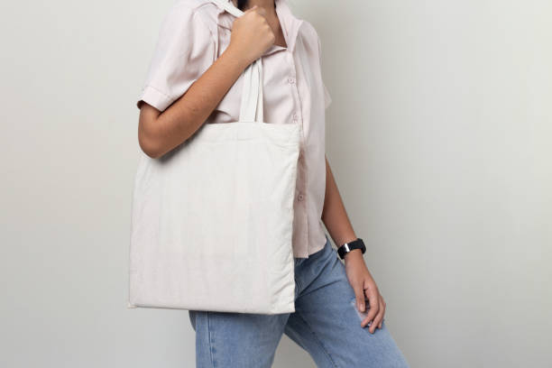 Mock-up girl carrying a white cloth bag On a white background stock photo