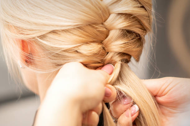 istock Female hands braiding pigtail to woman 1283710033