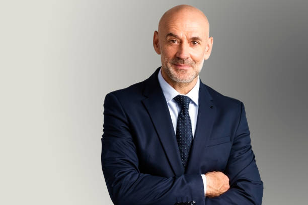 istock Senior businessman studio portrait while looking at camera and smiling 1283710575