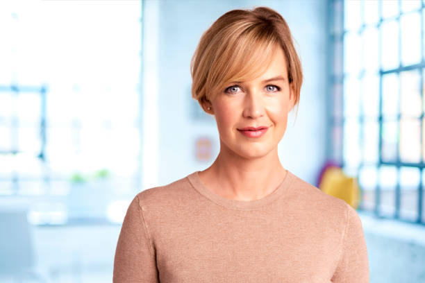 istock Smiling professional woman portrait while standing in the office 1283710592