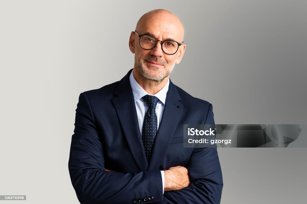 Executive businessman studio portrait Cropped shot of executive senior businessman wearing suit and tie while standing at isolated grey background. Copy space. Businessman Stock Photo