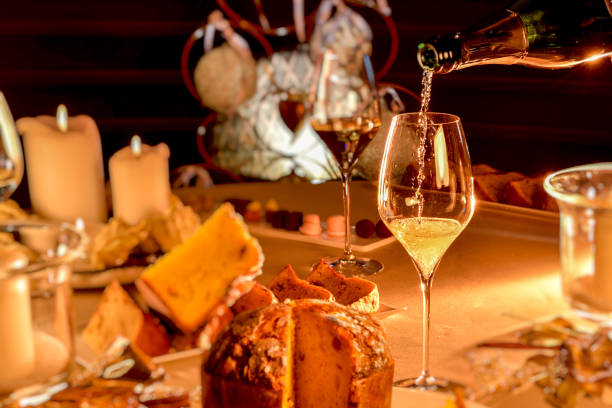 champagne is poured into glass on table set in Christmas style