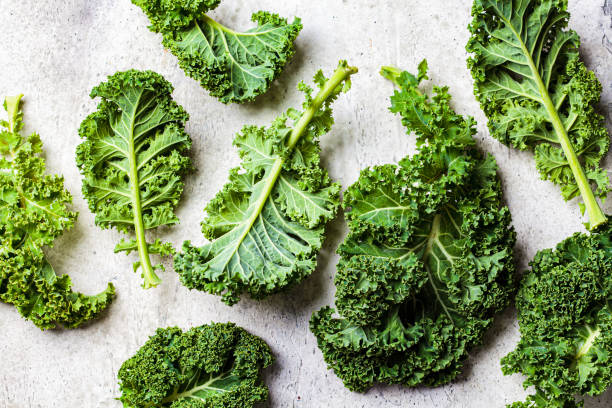 istock Fresh green kale leaves on gray background. 1283712968