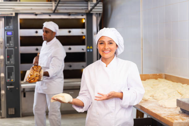 istock Woman baker smiling at camera during daily work with dough 1283713986