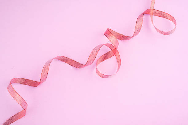 istock A beautiful ribbon on a gently pink background. Festive content. View from above, place for text. 1283715521