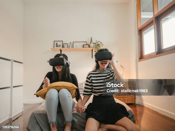 Asian Couple Lesbians Playing A Vr Device At Home Stock Photo - Download Image Now - Virtual Reality, Virtual Reality Simulator, Teenage Girls